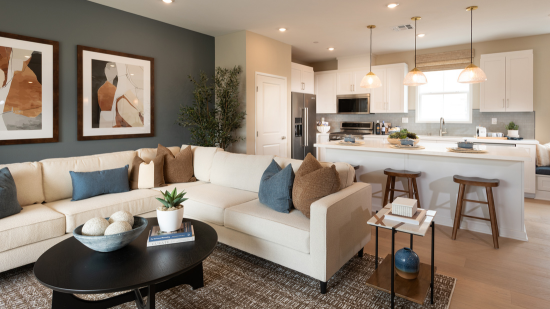 Sectional white couch with a light and bright kitchen in the background